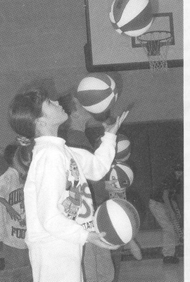 Kristin Reed juggles basketballs in a halftime show.