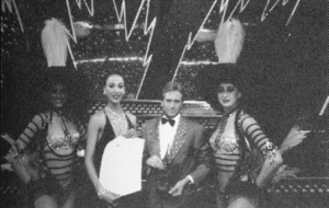 Kris Kremo with some of the Lido dancers and his International German Entertainment Award.